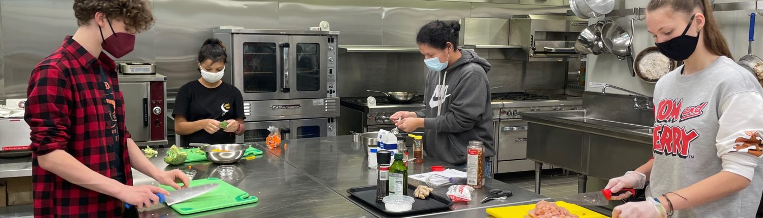 students prepare food in kitchen
