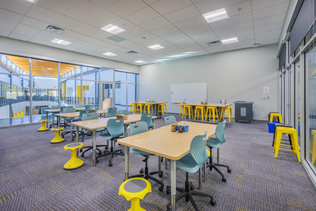 New desks with teal chairs and yellow stools