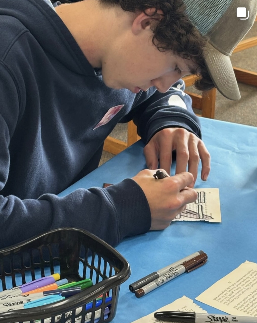 male student doing black out poetry