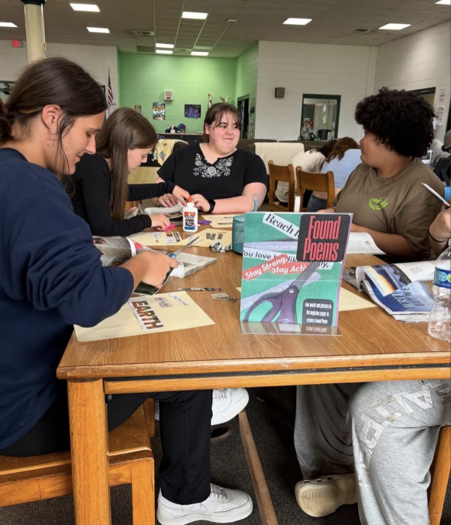 students at a table cutting out clippings