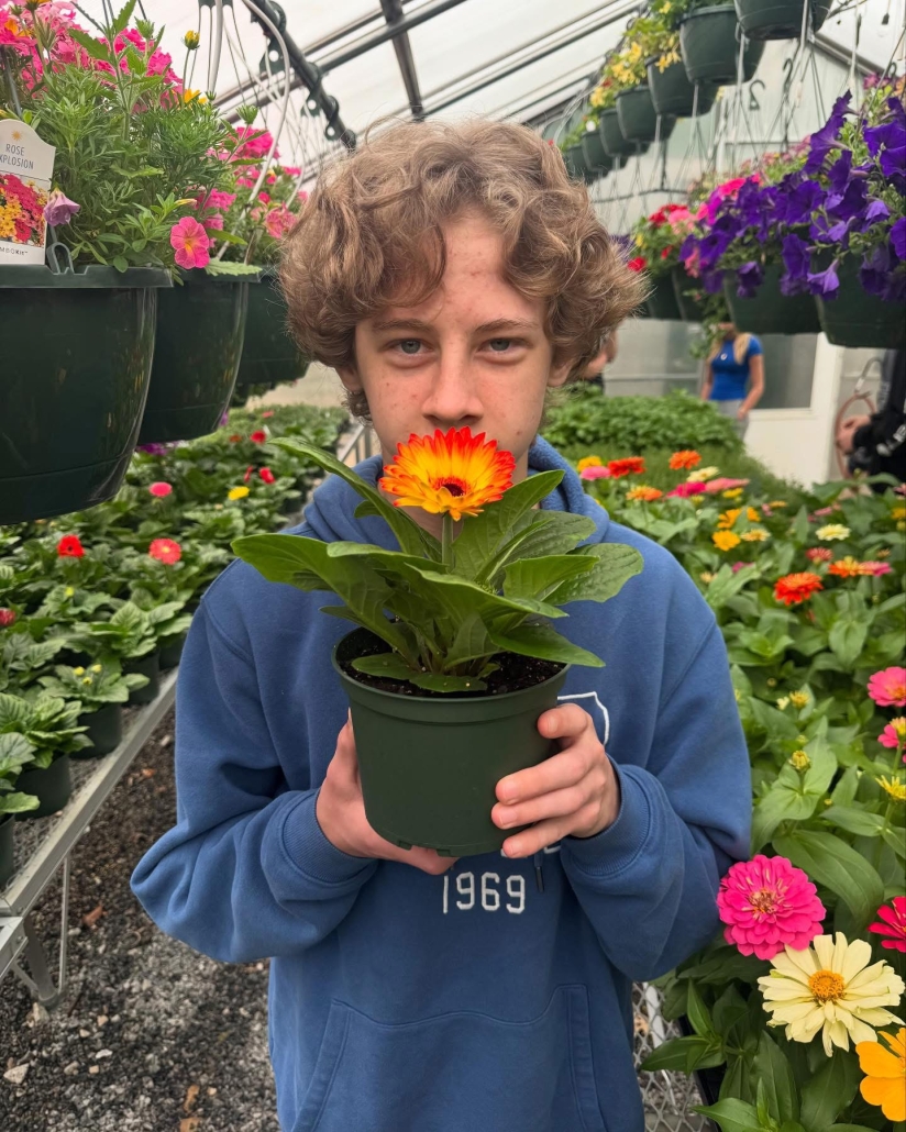 student holding up daisy