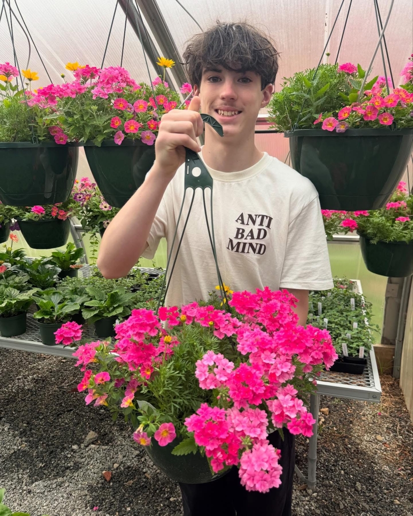student holding hanging plant 2