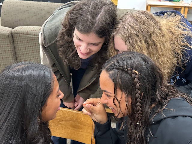 Three girls looking in one student's mouth