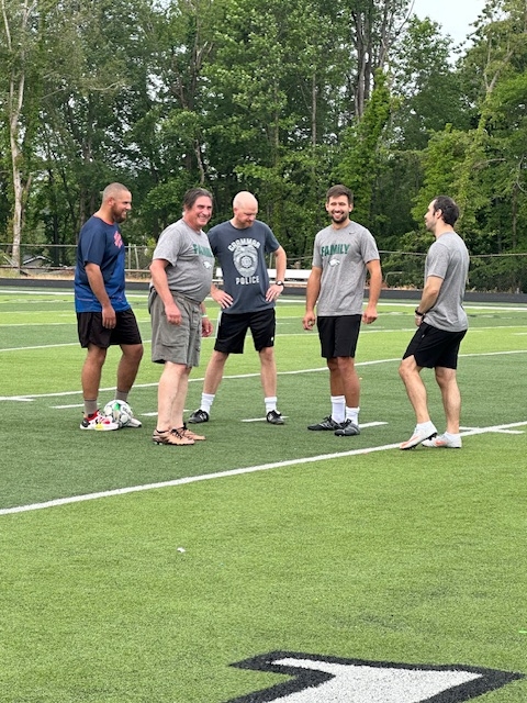 male staff on field laughing