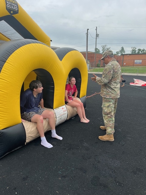 two students being instructed on inflatable by National Guard