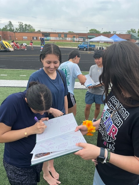 girls signing a yearbook