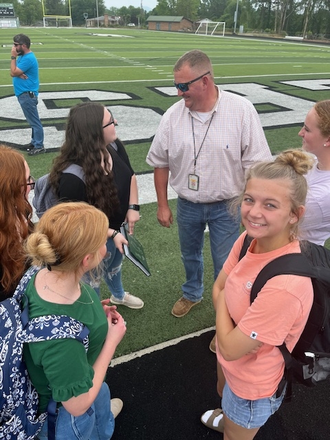 Mr. Rollins and FFA students on field