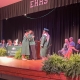 Adult and graduate on stage hugging