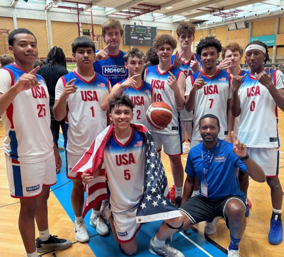 Gold winning team photo with everyone holding up #1