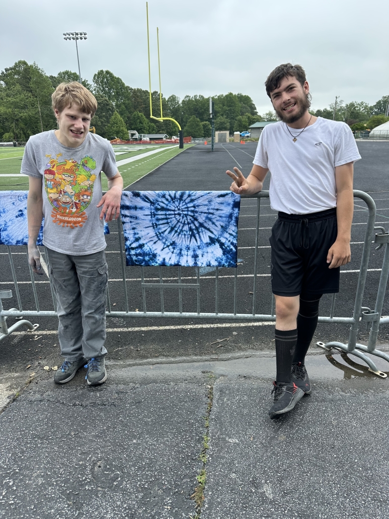 Phoenix and Brody with dyed towel on fence