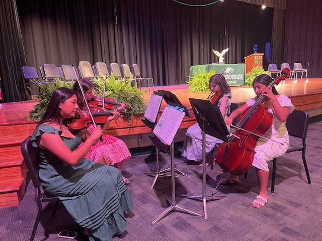 string quartet playing in auditorium