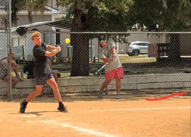 student hitting softball