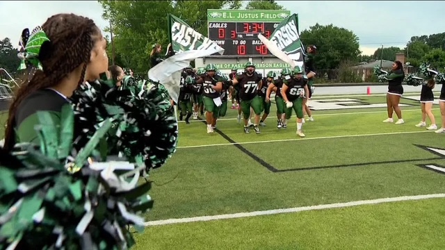 football players busting through sign to run on field