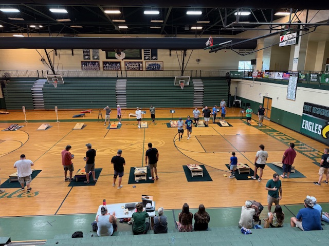 contestants playing cornhole - wide shot