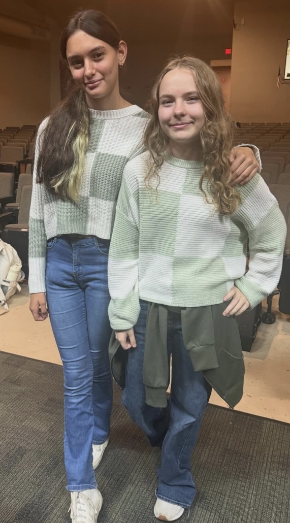 two girls twinning in matching sweaters