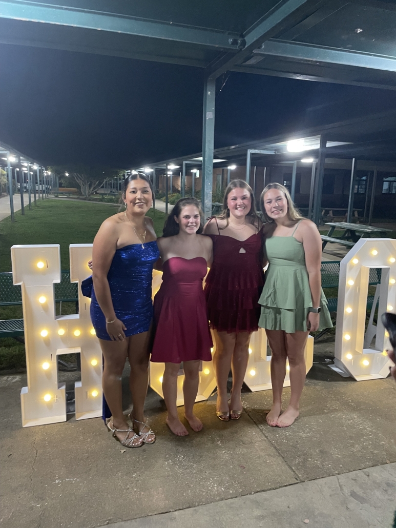 group of girls in front of HOCO sign