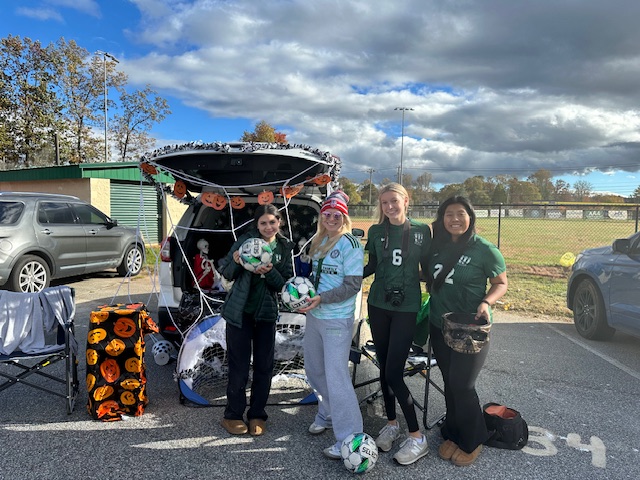 Soccer girls and coach at their soccer themed trunk