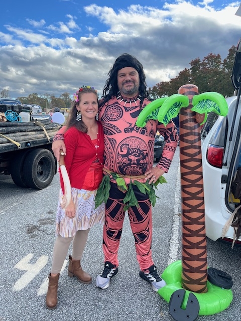 Mr. & Mrs. Justus in Moana costumes with palm tree