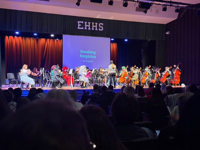Mrs. Quinn conducting orchestra on stage in costume