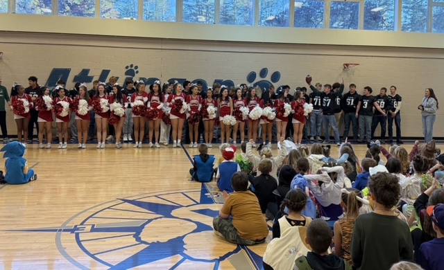 HHS cheerleaders and EHHS football team lined up in ATK gym