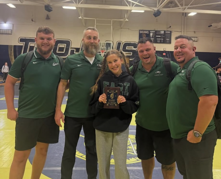 Mia with the coaching staff holding her MOW award