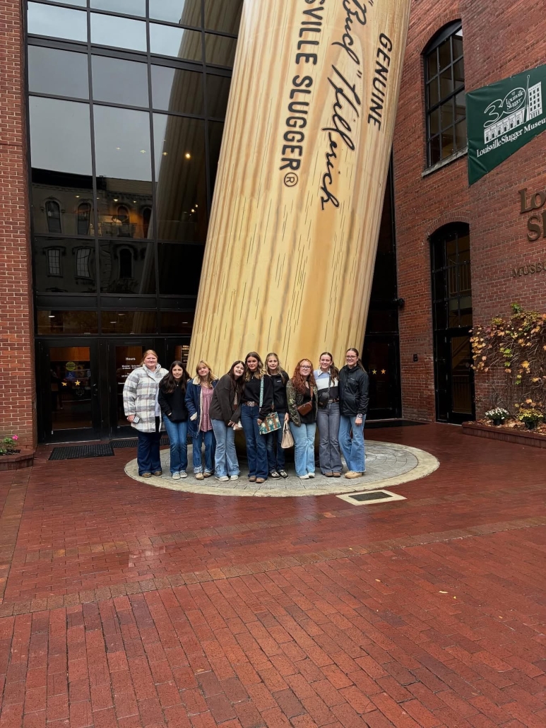 livestock team in front of giant bat at Louisville Slugger museum