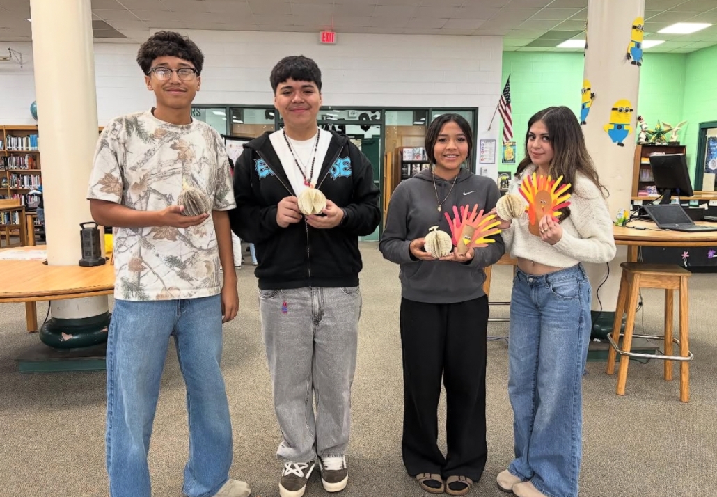Four students holding their Thanksgiving turkey crafts
