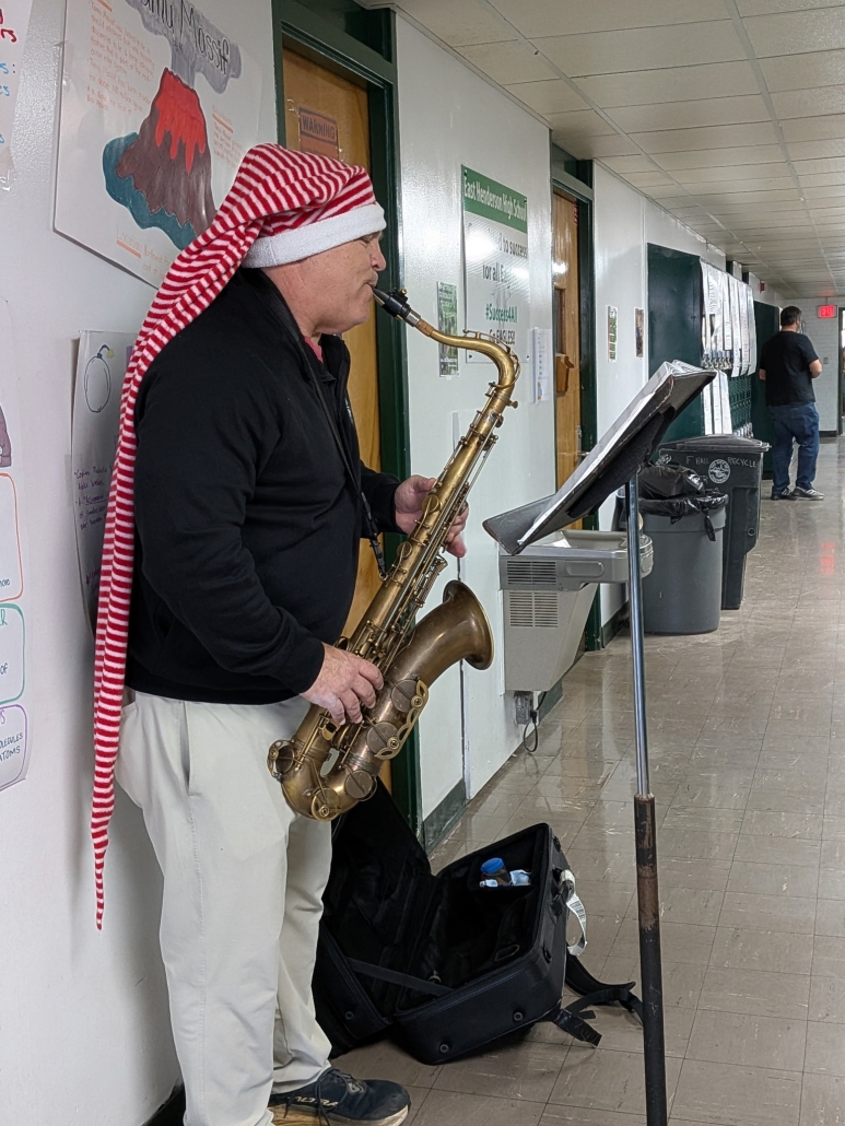 Mr. Smith playing saxophone in a holiday hat