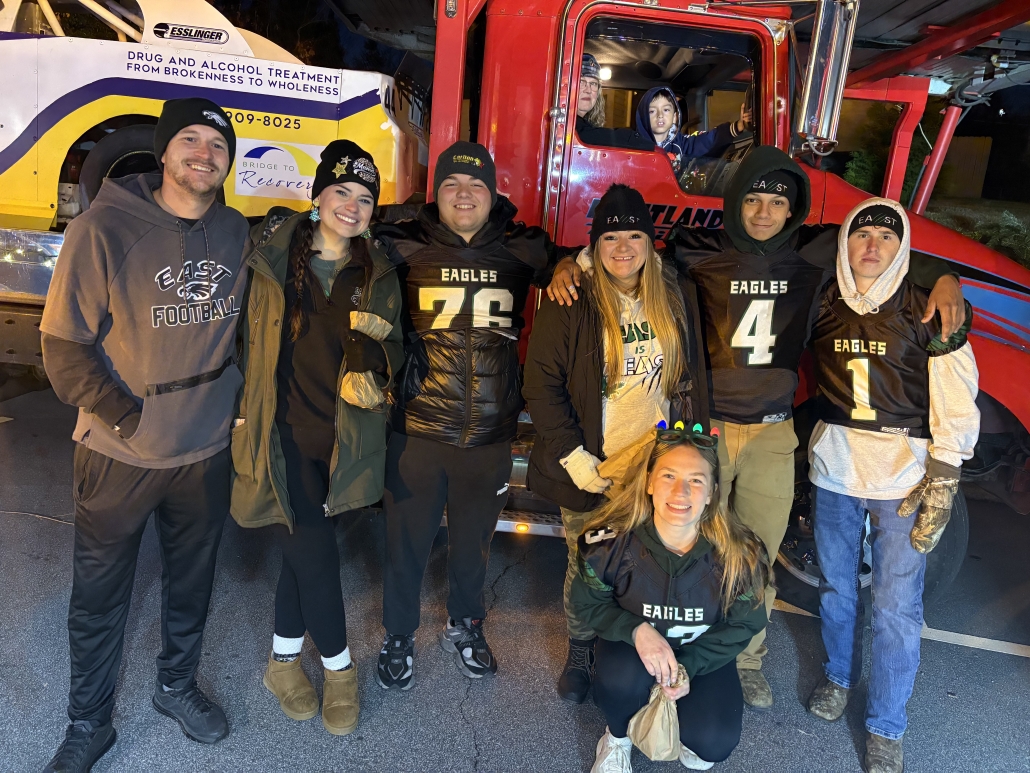 Football team members and friends in front of truck