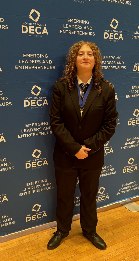 Stella with medal on DECA backdrop