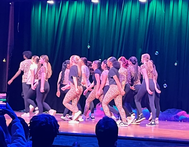 Dancers moving stage left in cheetah gear