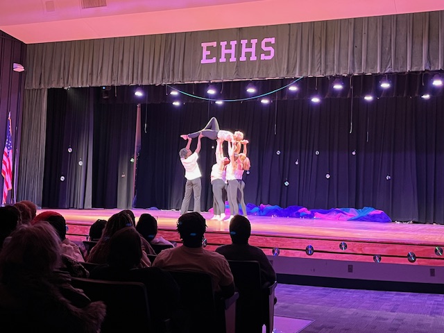 Dance group holding a dancer up in a pose