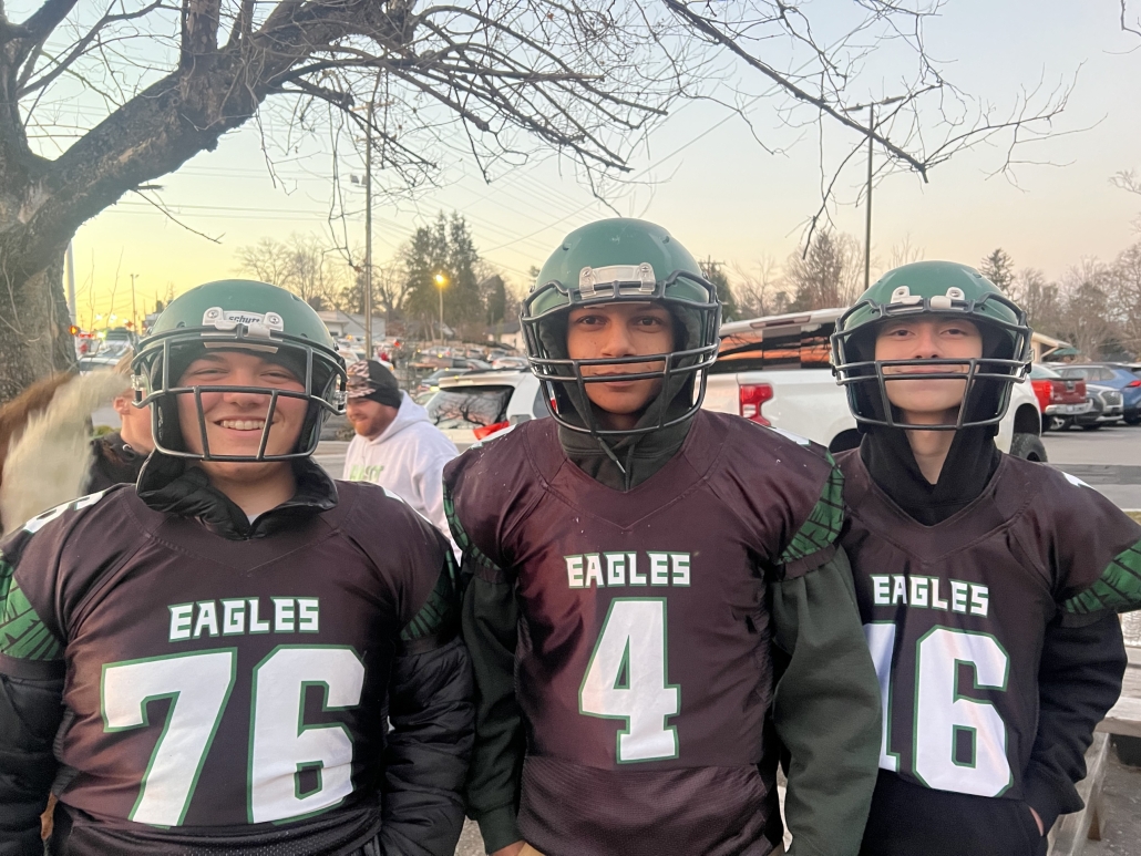 Three football players with helmets on
