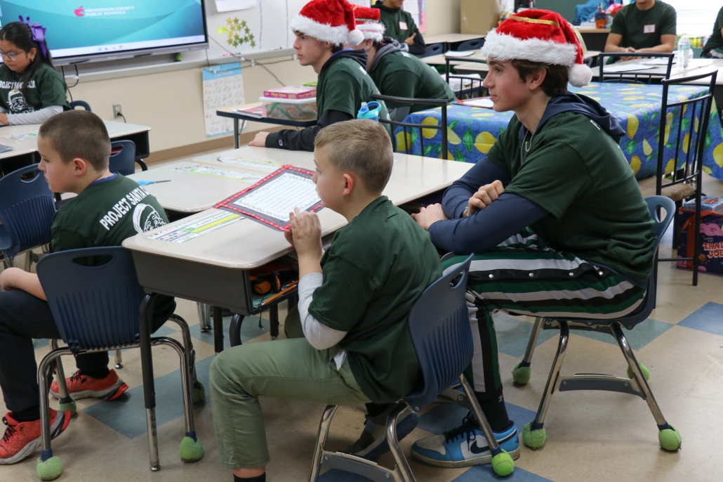 Students and basketball players listening to someone talk