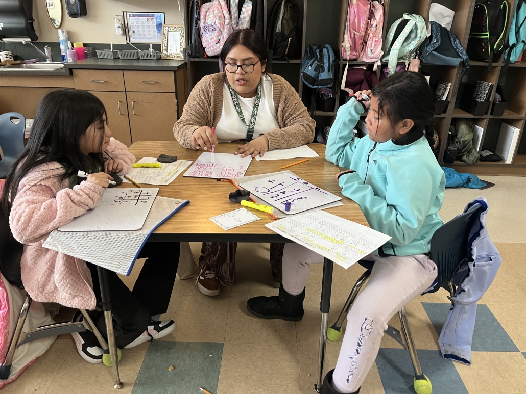 Shayla working with elementary students at a table