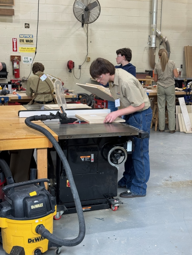 Wyatt leaning over to measure project