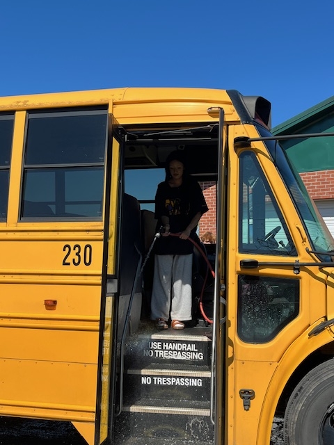 Jackie spraying out bus at door