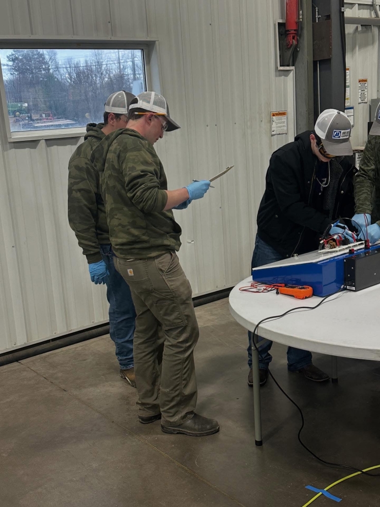 Two boys consulting while one works