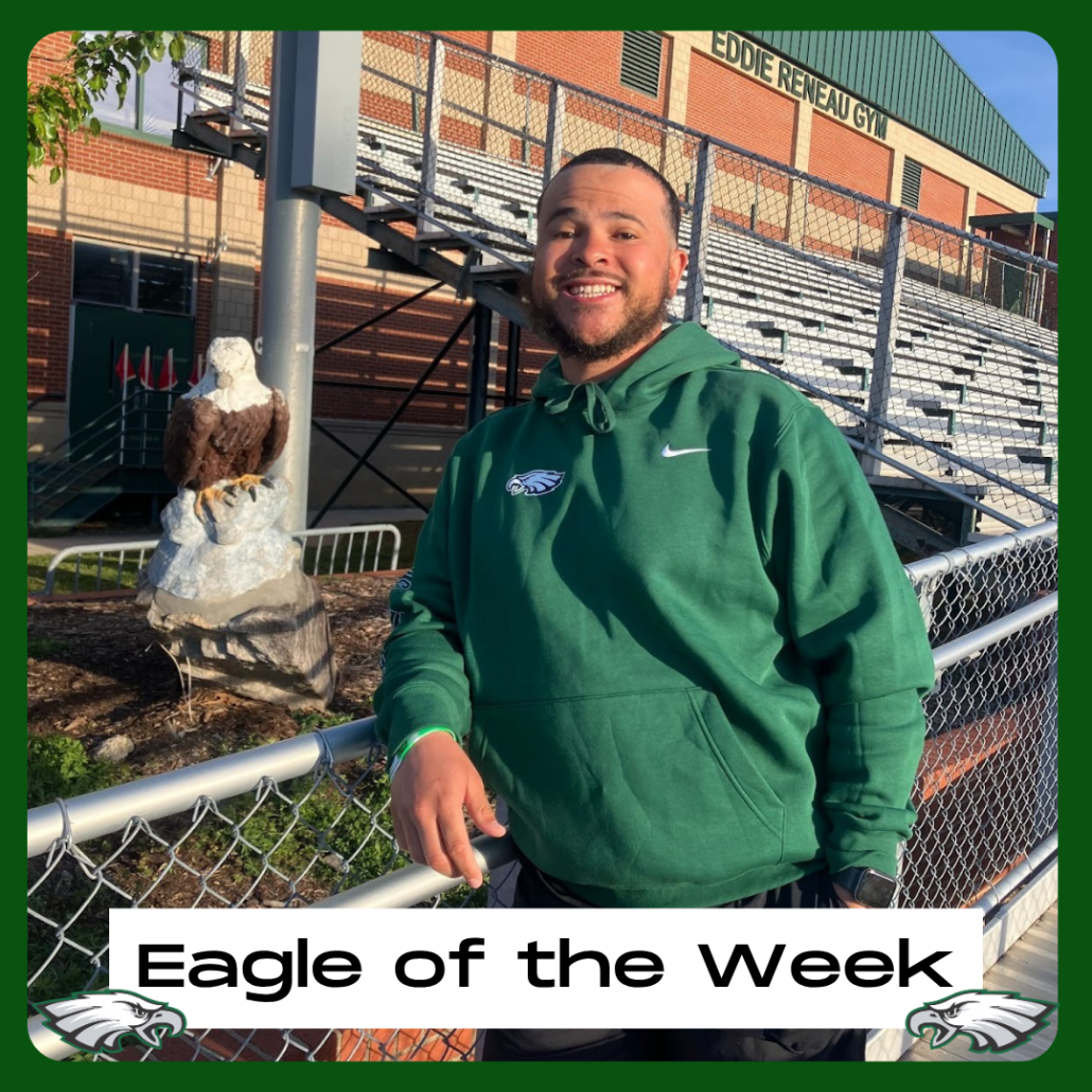 Coach Rudisill next to Eagle statue and bleachers in EOTW frame