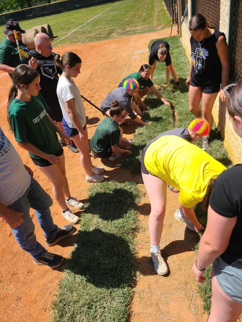 girls working to lay sod 
