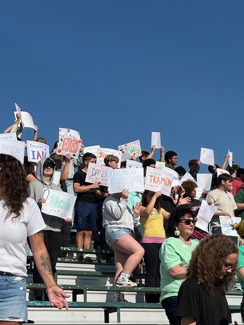 Students holding signs in the bleachers 1