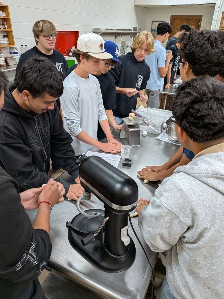 Boys working at culinary table with mixer