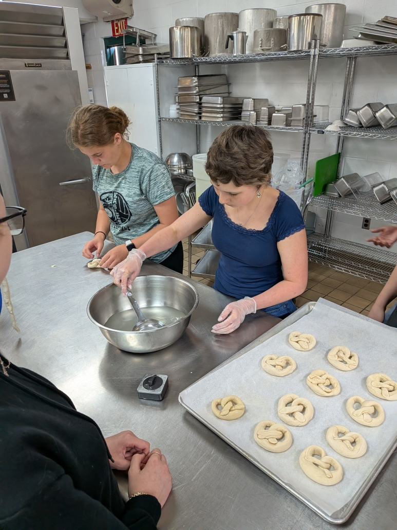 Two students working on measuring pretzel dough
