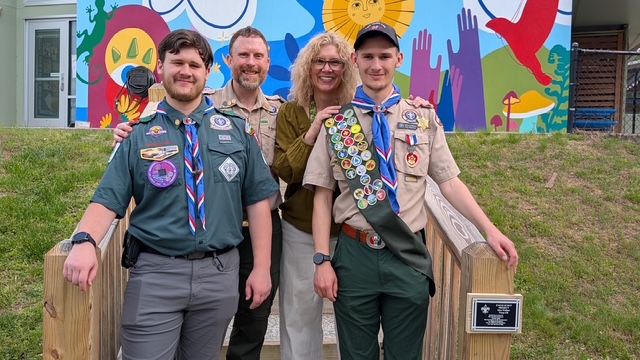 Mica & family standing by his Eagle project in uniform