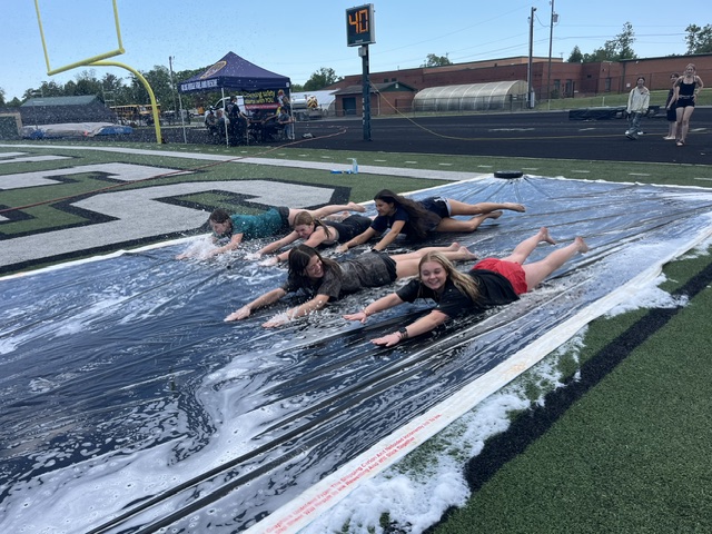 Girls sliding on slip n slide
