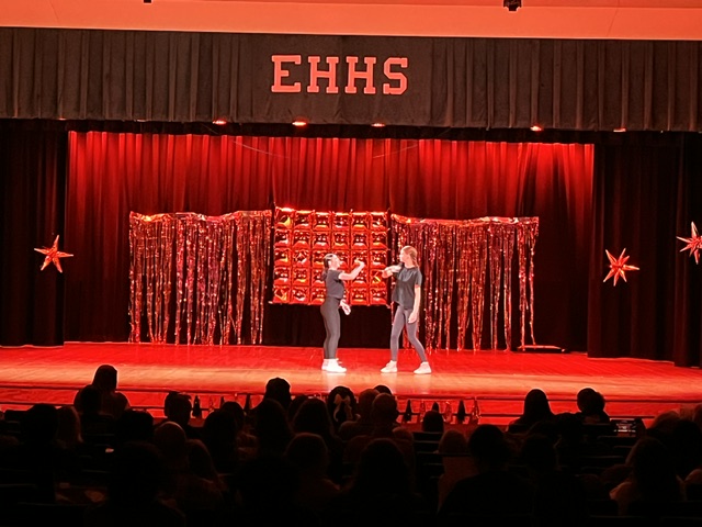duet doing handshake with red stage lights