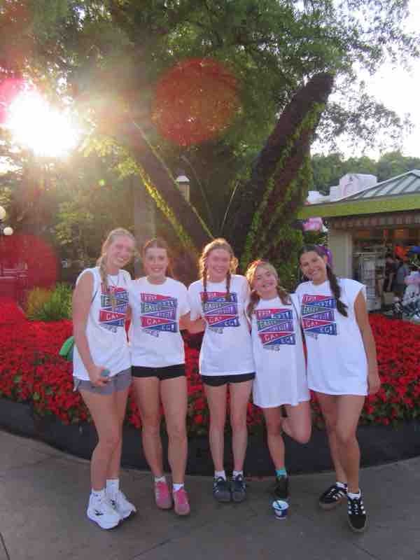 Five girls in front of flower bushes