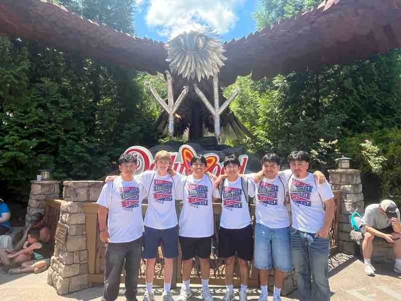 Six boys in front of Eagle statue