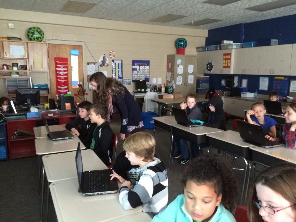 Entire classroom of students working in pairs on coding activities