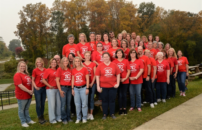 Group photo of the Hendersonville Elementary Staff wearing matching red tshirts that say Cubcat Strong for 50.